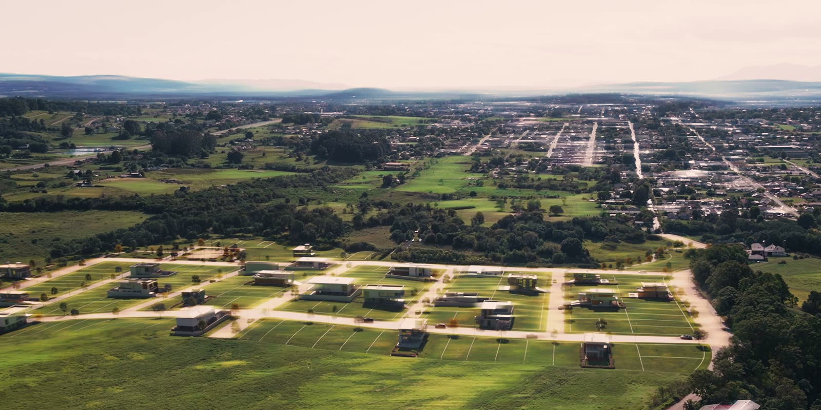 Vista aérea do Multiparque Taquara, no Rio Grande do Sul, com as quadras de terrenos demarcadas e a cidade de Taquara ao fundo